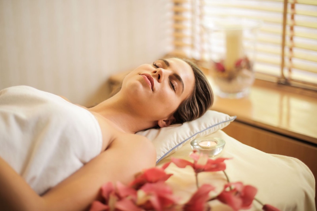 Client resting in a candle-lit treatment room
